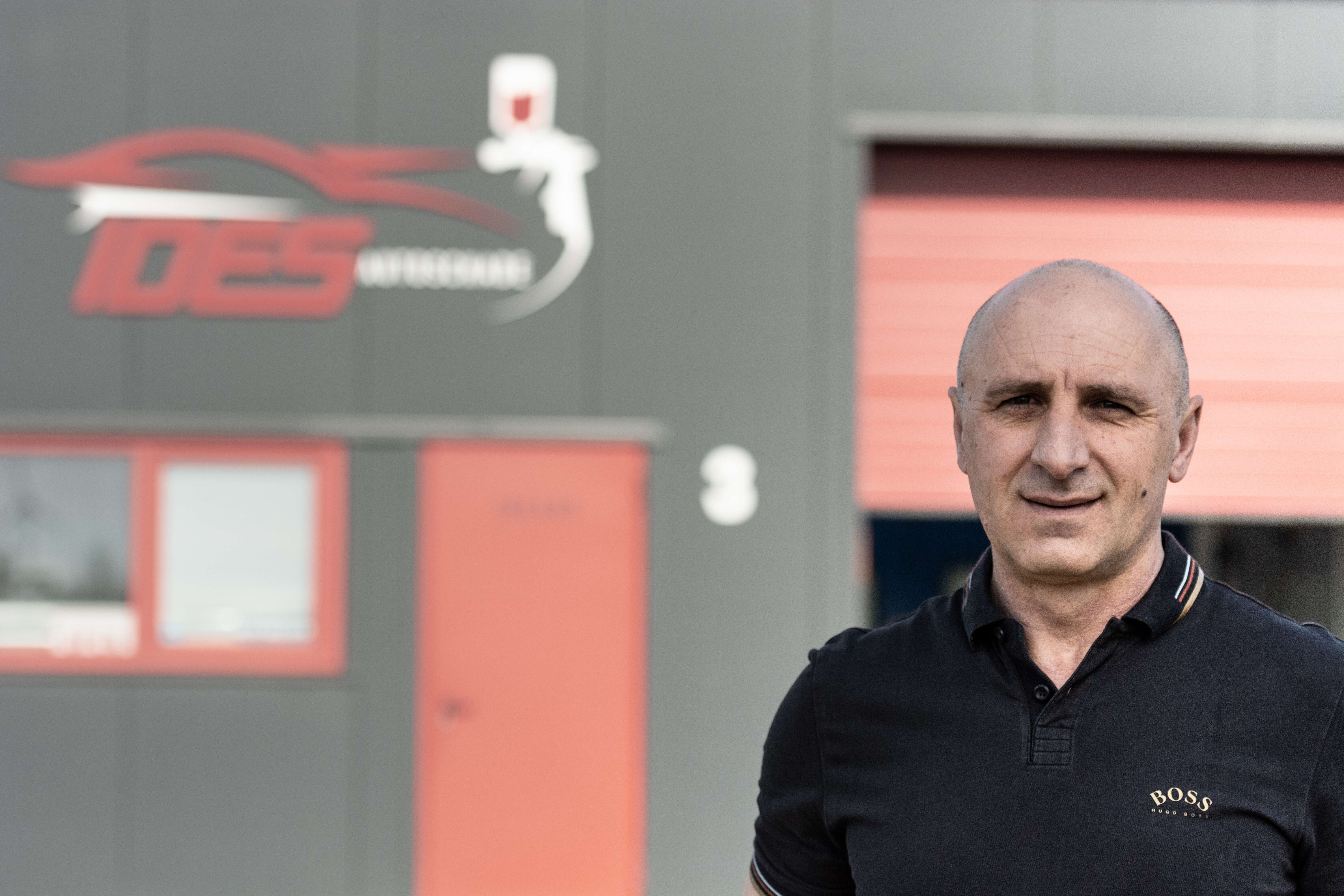 Irfan Pačariz die voor het gebauw van autoschadebedrijf IDES staat